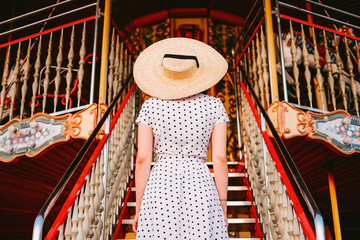 Elegant young lady standing at the staircase in amusement park