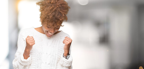 Beautiful young african american woman wearing winter sweater over isolated background very happy...