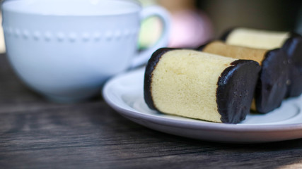 Banana roll cake from Bandung, West Java, Indonesia and a cup of drink on wood background.