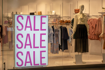 Season sale, black friday and shopping concept. Sale signs on stands in shop.