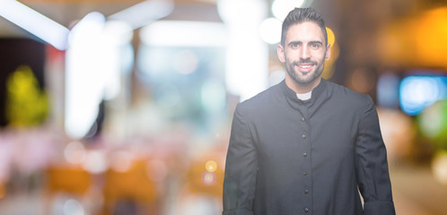 Young Christian priest over isolated background with a happy and cool smile on face. Lucky person.