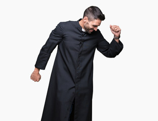 Young Christian priest over isolated background Dancing happy and cheerful, smiling moving casual...