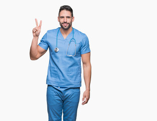 Handsome young doctor surgeon man over isolated background showing and pointing up with fingers number two while smiling confident and happy.