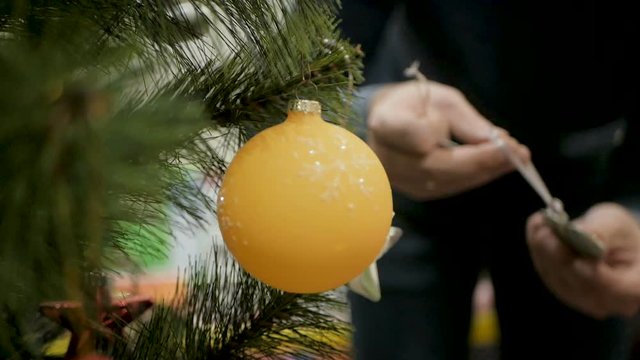 Happy family decorating a Christmas tree with boubles in the living-room