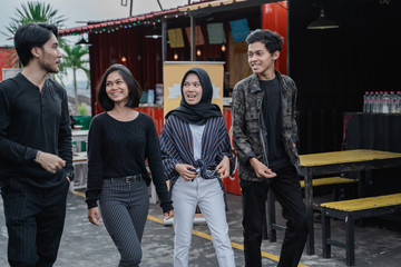 Four young friends walking posing on the way together when hanging out