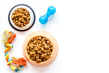Cat and dog dry food in bowl and toys on white background top view mockup