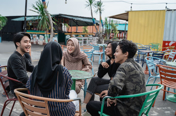 young people hanging out with friends in the outdoor cafe