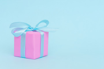 Gift pink box with blue satin ribbon on blue background, congratulations on Women's Day, mum's day, Valentine's day, happy birthday, Christmas