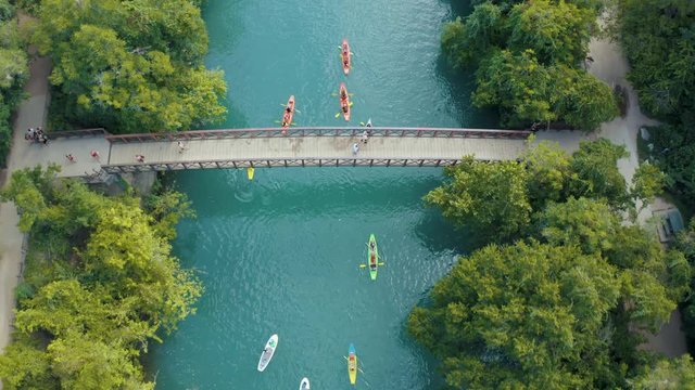 Cinematic 4K Aerial Footage of Bridge over Creek Ending with a Top Down Shot featuring people in Kayaks on the water