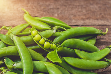 Fresh green peas or beans on wooden table