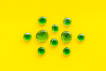 Pattern from colored glass stones on yellow background top view