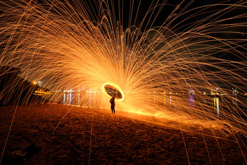 Steel wool spinning on beach with lots of sparks flying