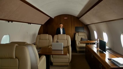 Confident businessman walking inside of private jet cabin - Powered by Adobe