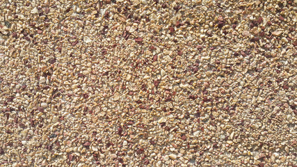 surface structure created by spraying, sifted sand painted crimson and cream small stones, building facades, wall, medium texture