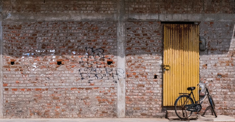 old door and bicycle and a brick wall