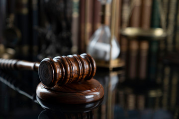 The law concept background.  Judge's gavel, legal books and the acale on the table in the old court...