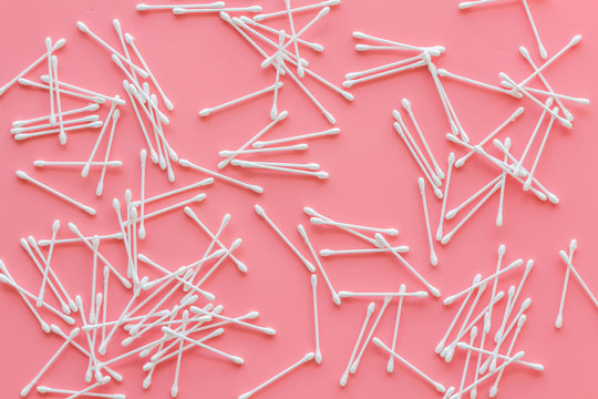 pattern of cosmetic cotton swabs on pink background top view
