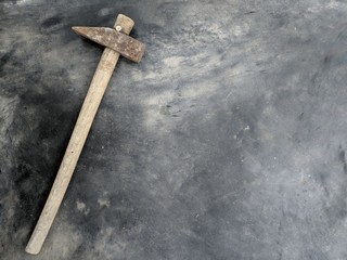The hammer on the handle is an old wood placed on a polished cement.