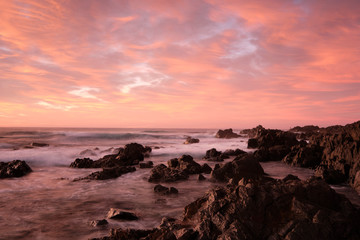 Fototapeta na wymiar Red sky sunrise with water motion and flow over rocks