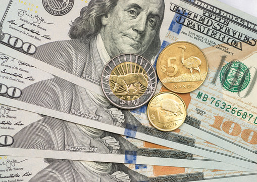 Peso Uruguayo coin on top of dollar bills