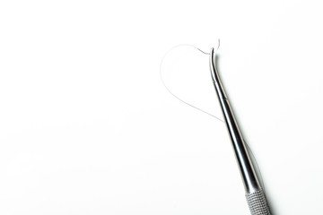 Curved needle holder for suture thread. White background with space for text.