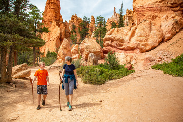 Senior woman and her grandson hiking together in Bryce Canyon National Park, Utah, USA looking out...
