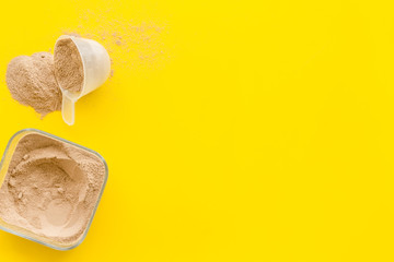 Sports nutrition with scoop and protein on yellow background top view space for text