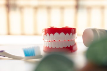 Close up Denture with toothpaste Toothbrush on blurred background.Metaphor for oral, dentures jaw toothy healthcare protect.
