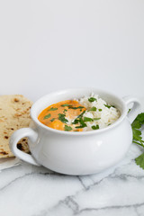 Indian butter chicken with rice, cilantro, and naan, copy space, white background