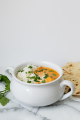 Indian butter chicken with rice, cilantro, and naan, copy space, white background