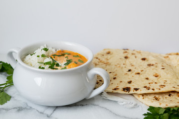 Indian butter chicken with rice, cilantro, and naan, copy space, white background