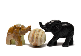figurines of elephants play on a white background