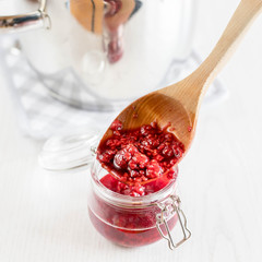 freshly made raspberry marmalade in wooden spoon