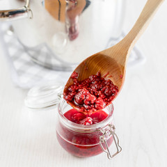 freshly made raspberry marmalade in wooden spoon