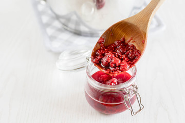freshly made raspberry marmalade in wooden spoon