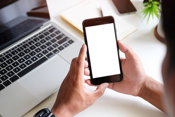 Cropped shot view of man hands holding smart phone with blank copy space screen for your text message or information content, female reading text message on cell telephone during in urban setting. 