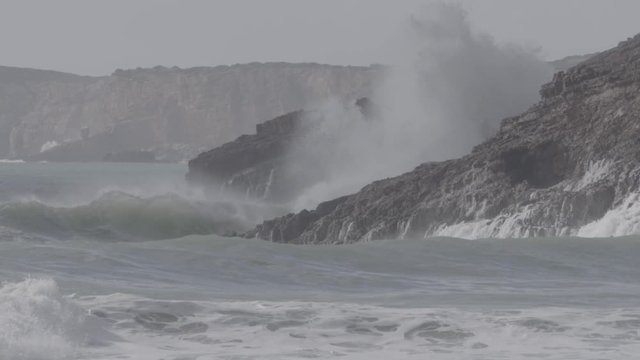 Algarve beach, with waves crashing in the rocks