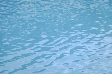 Blue swimming pool edge with refection of water ripple
