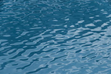 Blue swimming pool edge with refection of water ripple