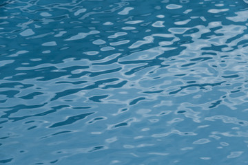 Blue swimming pool edge with refection of water ripple
