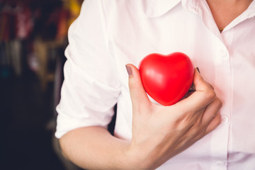woman hold red heart and wearing white shirt