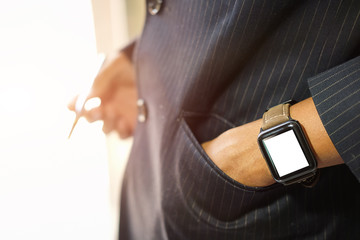 Cropped shot view of Businessman Looking At Smart Watch In Design Office .