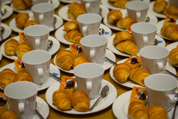 Row of croissants, cakes and a cup of coffee snacks for seminars