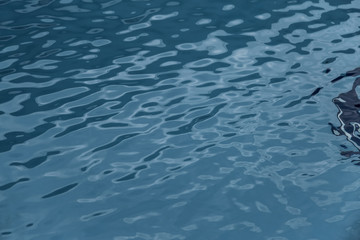 Blue swimming pool edge with refection of water ripple