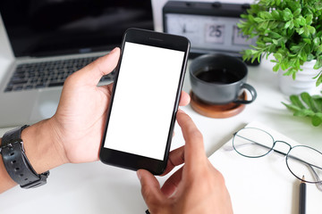 Cropped shot view of man hands holding smart phone with blank copy space screen for your text message or information content, female reading text message on cell telephone during in urban setting. 