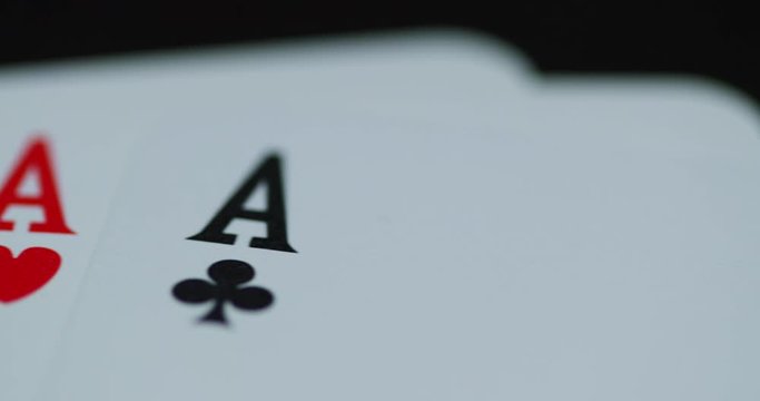 A close up macro shot of playing cards with all four aces hearths diamonds space cross lying on an elephant while moving as the cards slowly expose from the side.