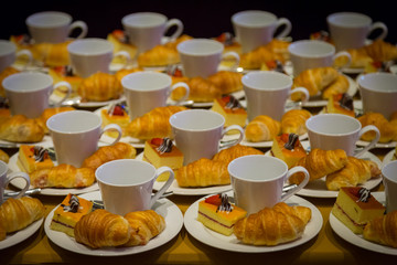 Row of croissants, cakes and a cup of coffee