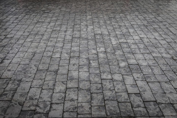 Road made of small pieces of old gray bright stone