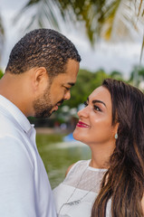 couple of young latin american men and women and happy in an outdoor portrait, together in a park, ju both romantically laughing and hugging