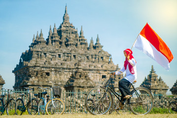 Asian Hijab flapper Indonesian flag in bicycle, Indonesia independence day